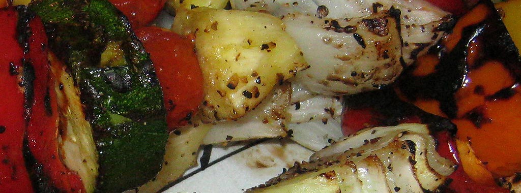Grilled vegetables with charred peppers, onions, and zucchini